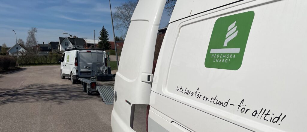 Två bilar märkta Hedemora Energi parkerade längs en väg.